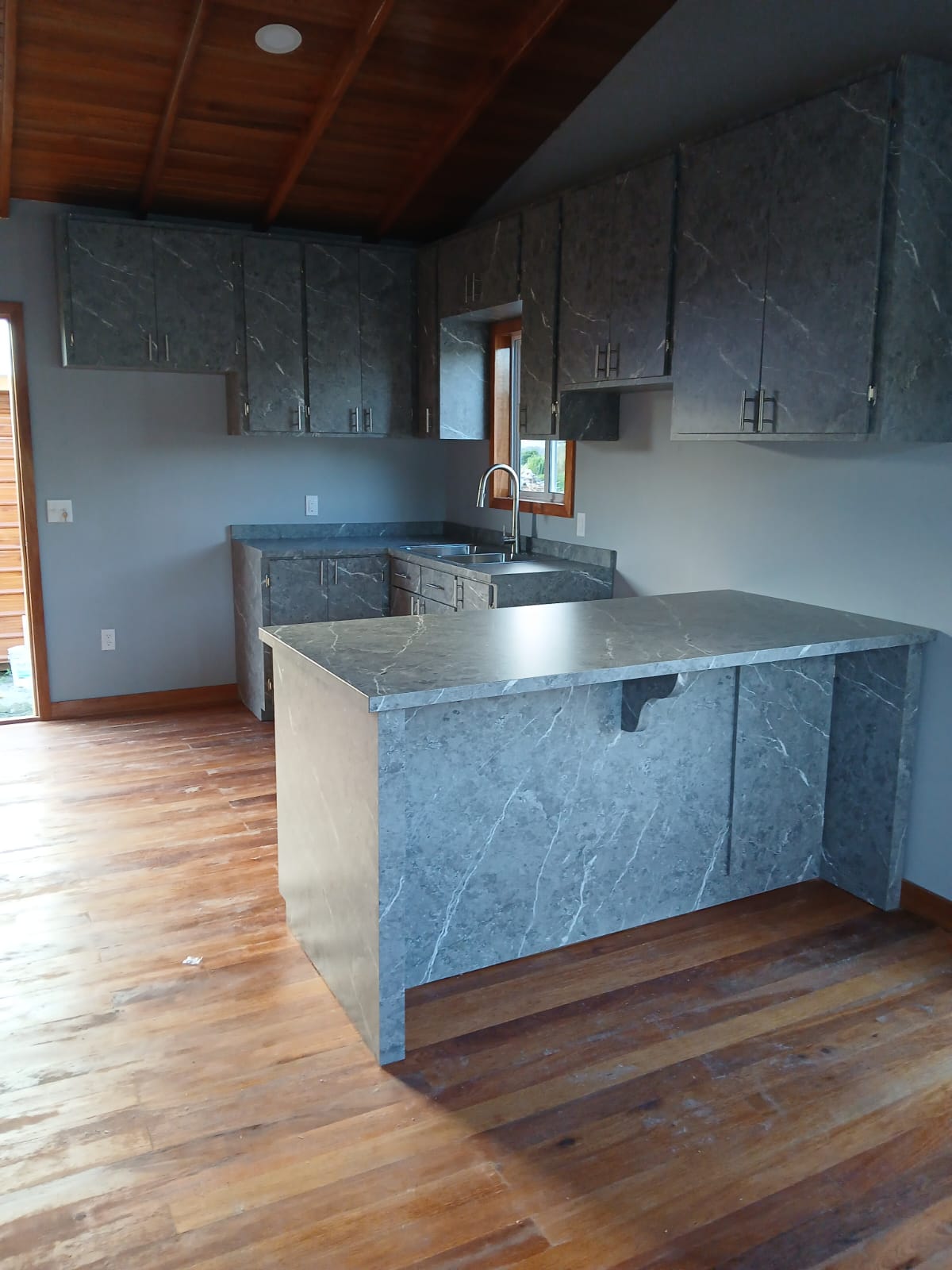 Custom stone-finish kitchen cabinetry with island